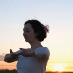 Woman_at_sunset_practicising_calm_qi_gong; Pulling_up_the_eart