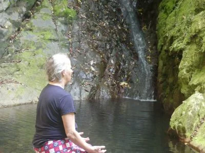 Helen Rowlands sitting by a waterfall breathing the fresh air. Pleasure Waves